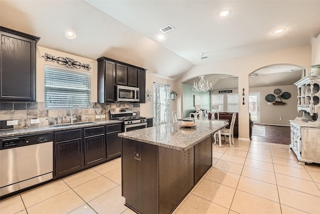 kitchen with a kitchen island, appliances with stainless steel finishes, sink, and light tile patterned floors