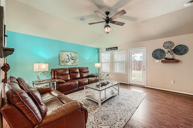 living room featuring a raised ceiling, hardwood / wood-style floors, and ceiling fan