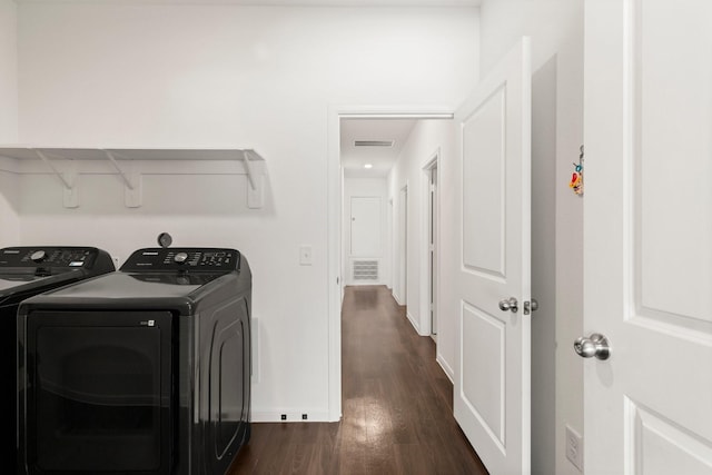 washroom with dark hardwood / wood-style flooring and washer and clothes dryer