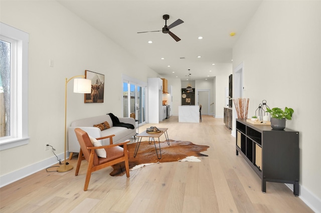 living area featuring ceiling fan and light hardwood / wood-style flooring