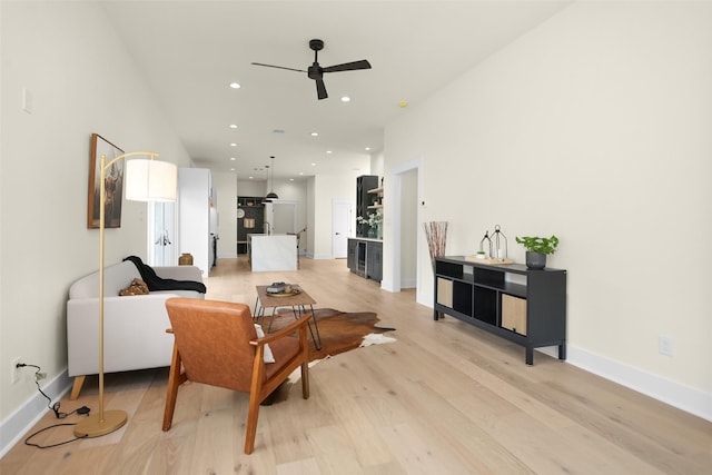 living room featuring light hardwood / wood-style floors and ceiling fan