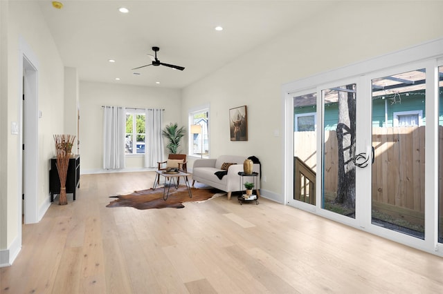 living area with ceiling fan and light wood-type flooring