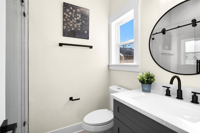 bathroom featuring vanity, toilet, and a shower with door