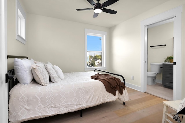 bedroom featuring ceiling fan, ensuite bath, and light hardwood / wood-style floors