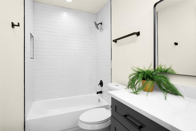 full bathroom featuring vanity, tiled shower / bath combo, and toilet