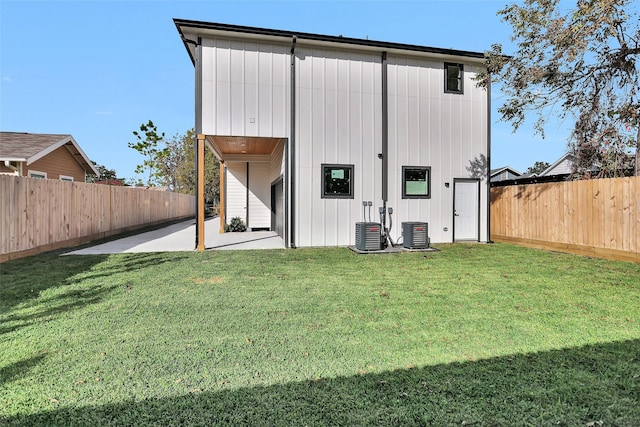 back of property with a yard, central air condition unit, and a patio area