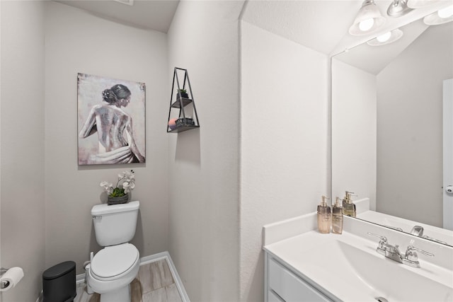 bathroom with vanity, vaulted ceiling, and toilet