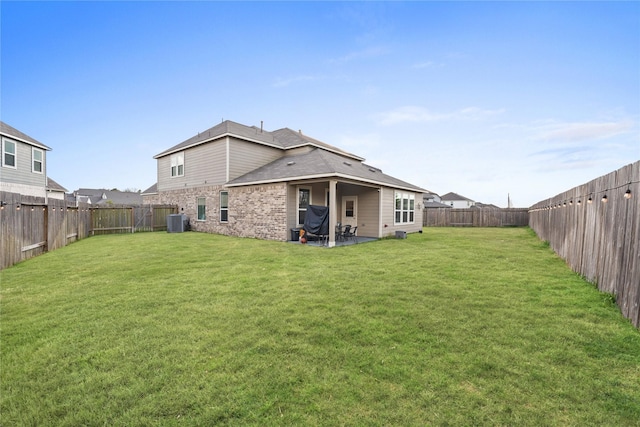 rear view of house featuring central AC and a lawn