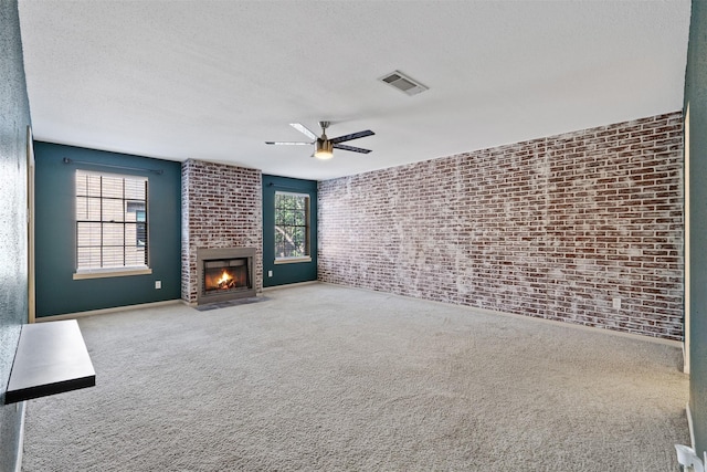 unfurnished living room featuring light colored carpet, a healthy amount of sunlight, and a textured ceiling