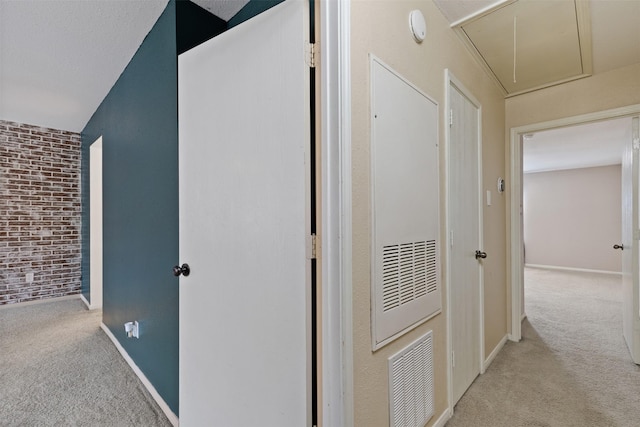 hall with brick wall and light colored carpet