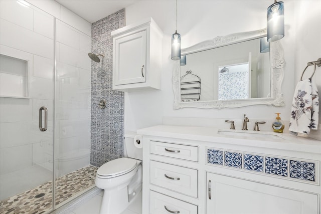 bathroom with vanity, a shower with shower door, and toilet