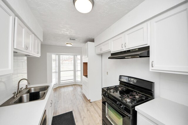 kitchen featuring white cabinetry, light hardwood / wood-style floors, black gas stove, and sink