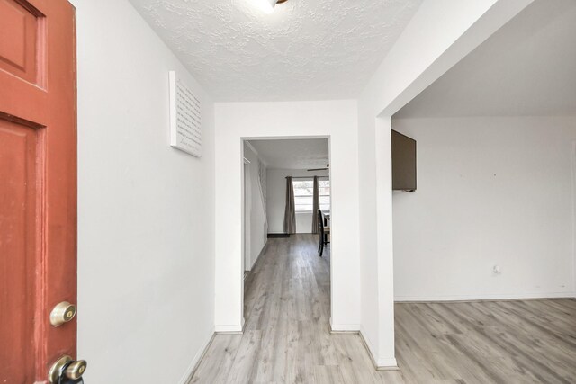 hallway featuring a textured ceiling and light wood-type flooring