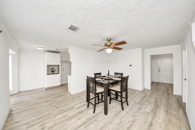 dining room featuring ceiling fan, a textured ceiling, and light wood-type flooring