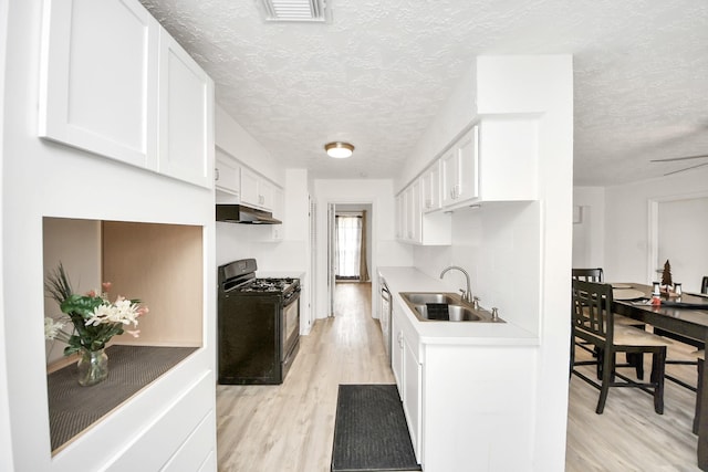 kitchen featuring sink, gas stove, white cabinetry, a textured ceiling, and light hardwood / wood-style floors