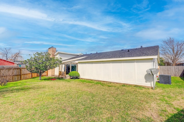 back of property with a yard and central air condition unit