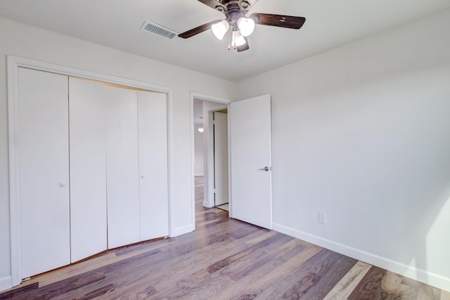 unfurnished bedroom featuring ceiling fan, a closet, and light hardwood / wood-style flooring