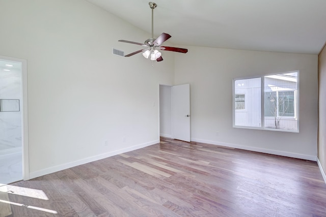 empty room with ceiling fan, high vaulted ceiling, and light hardwood / wood-style flooring