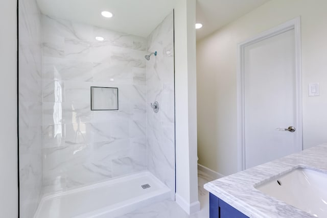 bathroom with vanity and a tile shower