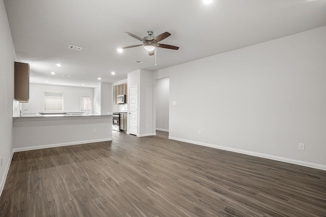 unfurnished living room featuring ceiling fan, sink, and dark hardwood / wood-style floors