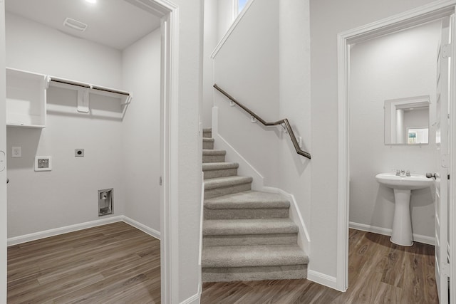 stairs with hardwood / wood-style flooring and sink