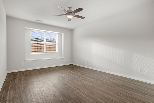 spare room with ceiling fan and dark wood-type flooring