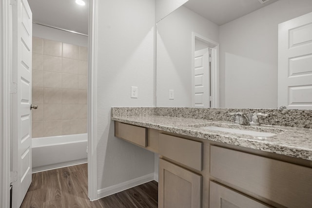 bathroom with tiled shower / bath combo, vanity, and hardwood / wood-style floors