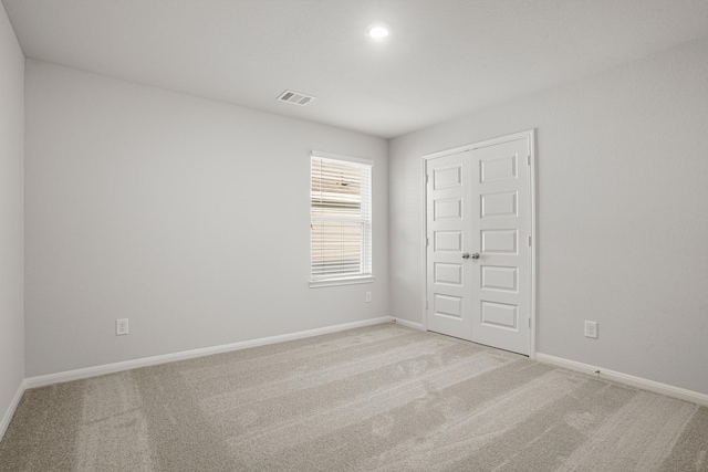 unfurnished room featuring light colored carpet