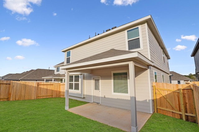 back of house featuring a patio area and a lawn