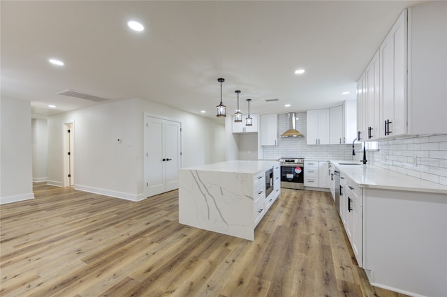 14142 Rosetta Dr, Cypress, TX 77429 - kitchen with stainless steel appliances, wall chimney range hood, decorative backsplash, light stone counters, and a kitchen island
