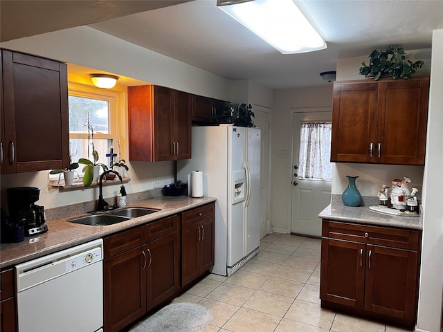 kitchen featuring sink, white appliances, plenty of natural light, and light tile patterned flooring