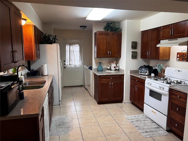 kitchen featuring white appliances, stone countertops, sink, and light tile patterned floors