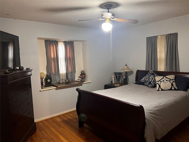 bedroom with dark hardwood / wood-style floors and ceiling fan