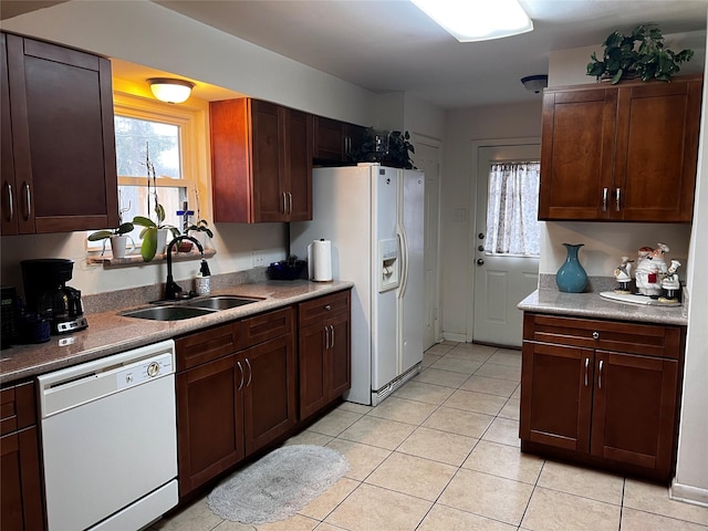 kitchen with sink, light tile patterned floors, and white appliances