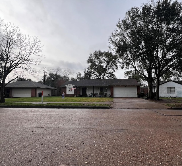 single story home featuring a garage and a front lawn