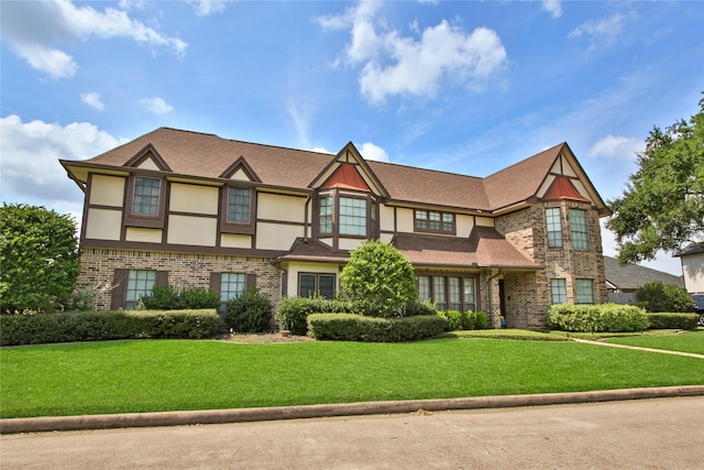 tudor home featuring a front yard