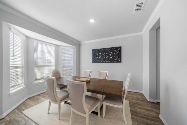 dining area with crown molding and wood-type flooring