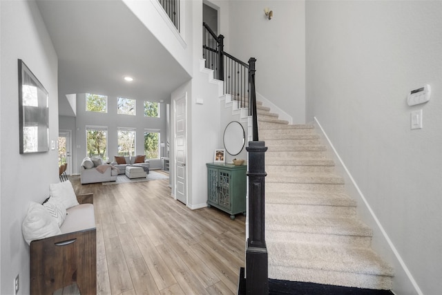 staircase with hardwood / wood-style flooring and a high ceiling