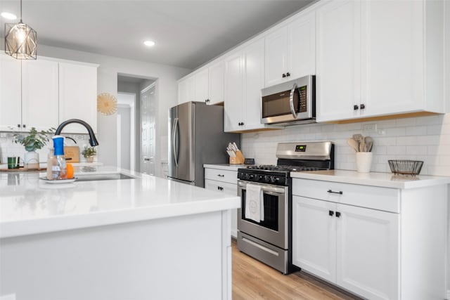 kitchen with appliances with stainless steel finishes, sink, and white cabinets