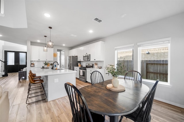 dining area with plenty of natural light, light hardwood / wood-style floors, and sink