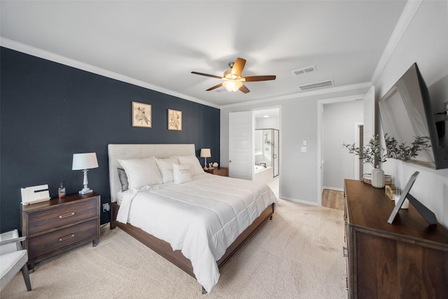 bedroom with ceiling fan, light colored carpet, ornamental molding, and ensuite bath