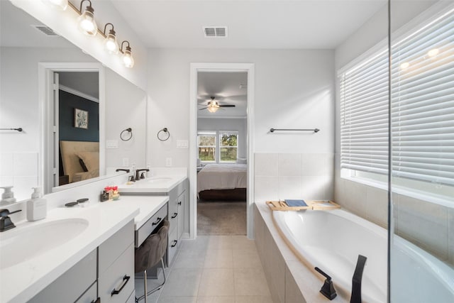 bathroom featuring vanity, tiled tub, tile patterned flooring, and ceiling fan