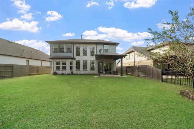 rear view of property featuring a lawn and a patio area