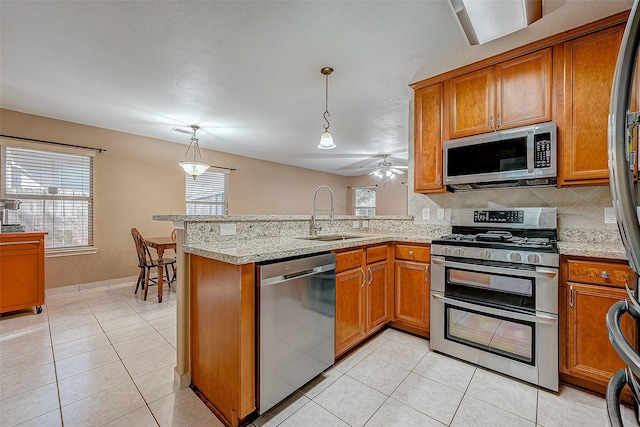 403 Crosby Village Dr, Crosby, TX 77532 - kitchen with decorative light fixtures, appliances with stainless steel finishes, sink, and kitchen peninsula