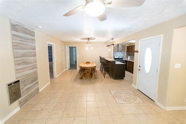 tiled foyer with heating unit, ceiling fan, and a textured ceiling