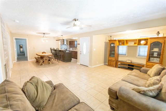 tiled living room with ceiling fan and a textured ceiling