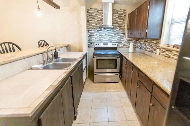 kitchen with light tile patterned flooring, sink, backsplash, wall chimney exhaust hood, and stainless steel electric range