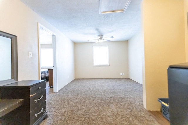 living room featuring light colored carpet, a textured ceiling, and ceiling fan