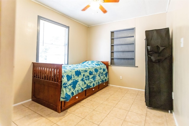 tiled bedroom with ornamental molding and ceiling fan