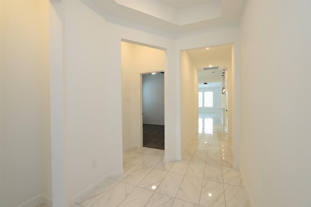 hallway with marble finish floor, baseboards, and visible vents